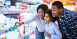 © Prostock-studio - Happy African American family buying milk products at modern supermarket, empty space. Millennial black parents and their daughter purchasing groceries at mall, choosing fresh food