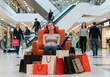 © Rima Akter - Black friday tired woman resting on a chair after shopping in the mall