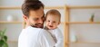 © Kazakov - The joyful moment between a father and his smiling baby in a cozy home.