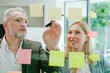 © Westend61 - Business colleagues brainstorming with adhesive notes in modern office