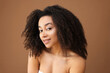 © New Africa - Portrait of beautiful Brazilian woman on light brown background