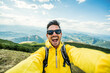 © Davide Angelini - Young hiker man taking selfie portrait on the top of mountain - Happy guy smiling at camera - Hiking, sport, travel and technology concept - Bright filter