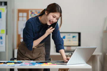 female coder or developer working using a computer display and smartphone in problem solving at work