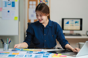 female coder or developer working using a computer display and smartphone in problem solving at work