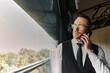 © LIGHTFIELD STUDIOS - A confident and handsome man in a suit engages in a phone conversation at a stylish cafe.