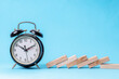 © Queenmoonlite Studio - Alarm Clock Stands Beside Toppled Dominoes, Suggesting The Passage Of Time