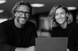 © Jane_S - Caucasian male and female adults smiling in office setting with laptop