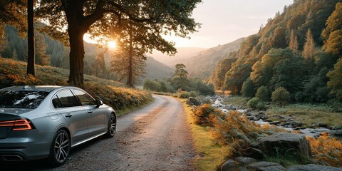 Wall Mural - Silver car on serene rural road at sunset amid lush forest and flowing river