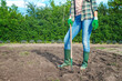 © Todayphoto - Woman in jeans working with hoe on soil. Farmer working in field, loosening soil. Agriculture.