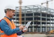 © Muhammad - Engineer with a digital tablet managing a building project on a construction site.