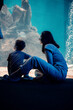 © Doralin - Mother and son observing marine life in large aquarium tank