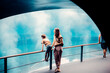 © Doralin - Family observing marine life in large aquarium tank