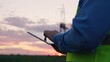 © TO LOVE - technology concept with high voltage power lines. electrical engineer helmet digital tablet sunset. power engineer power plant high voltage voltage energy. concept electrical engineer working sunset.