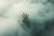 © Moon - A lone hand reaching through a small gap in a thick fog the fingers blurred symbolizing the search for connection