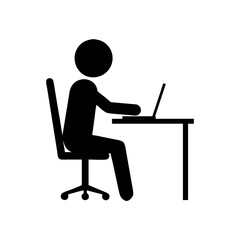 Silhouette of a person working on a laptop at a desk