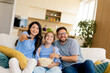 © BGStock72 - Family enjoys movie night together in cozy living room with popcorn