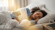 © LAB IMAGE - Woman peacefully sleeping in bed, sunlight streaming through window.