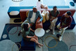 © StratfordProductions - Group of diverse coworkers sitting on colorful sofas having casual conversation in office lounge