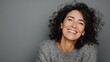 © Johannes - portrait of mature woman laughing against grey background successful middle aged woman in casual with toothy smile looking at camera cheerful happy beautiful latin lady smiling with copy space no log