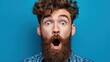 © Johannes - close up shot of emotive shocked bearded young male opens mouth widely stare at camera points upwards aside at blank space says wow its something unbelievable people and emotions concept no logos no