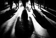 © Kia - A black and white image depicting silhouetted figures walking with long, dramatic shadows