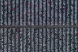 © AmazingAerialAgency - Aerial view of a grid of symmetrical rows of white vehicles with red accents, creating a stark contrast against the dark background, Sweden.