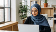 © Yvonne Bogdanski - Unternehmerin mit Hijab am Laptop im modernen Büro