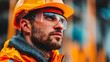 © Shahazadi - Close up of a worker wearing a yellow hard hat and safety glasses looking upwards intently