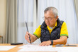 © leungchopan - Elderly asian man writing calligraphy with brush
