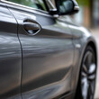 © SashaMagic - Close-up of a modern car door in an urban setting.