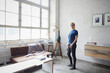 © Westend61 - Woman standing in modern loft with industrial charm