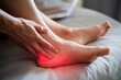 © Risat Designer - Close up of a person s foot experiencing heel pain with a hand gently massaging the inflamed area highlighted in red