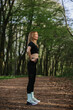 © dsheremeta - Woman exercising in a serene forest setting