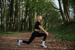 © dsheremeta - Woman stretching in forest during outdoor workout