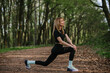 © dsheremeta - Woman stretching in a serene forest setting