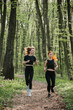 © dsheremeta - Women jogging through a forest trail