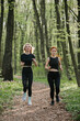 © dsheremeta - Women jogging through a forest trail