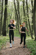 © dsheremeta - Women jogging through a serene forest trail