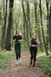 © dsheremeta - Women jogging in a serene forest path