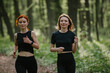 © dsheremeta - Two women jogging through a forest trail