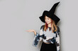 © Denira - Young girl dressed as a witch holding out her hand