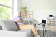 © Pixel-Shot - Muslim businesswoman with cup of coffee sitting on sofa at home