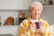© Pixel-Shot - Senior woman with glass cup of butterfly pea flower tea in kitchen