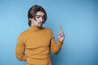 © bodnarphoto - portrait of young man gestures thoughtfully, evoking curiosity on blue background