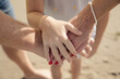 © hemminetti - Drei Generationen halten sich an den Händen am Strand – Symbol für Familie, Zusammenhalt und Liebe