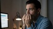 © Michele - A man sitting at a desk, staring at a computer screen with a worried expression.