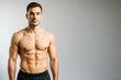 © Nargiz - High-resolution portrait of a confident, shirtless man with a muscular, defined physique standing against a gradient background. This image is perfect for fitness, health, supplement, sports branding