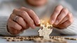 © Nataliia_Trushchenko - A woman is holding a puzzle piece in her hand. The puzzle piece is a wooden head with a light shining on it. The woman is focused on the puzzle piece