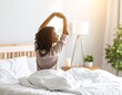 © Hexden - Woman Stretching in Bed with Morning Light