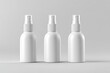 © Irfan - Three identical, white spray bottles, positioned side-by-side on a plain light gray background.  Each bottle has a rounded body and a clear spray top